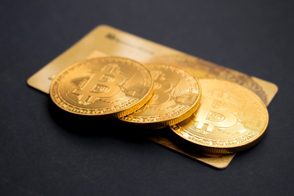 three round gold-colored Bitcoin tokens cryptocurrency and blockchain